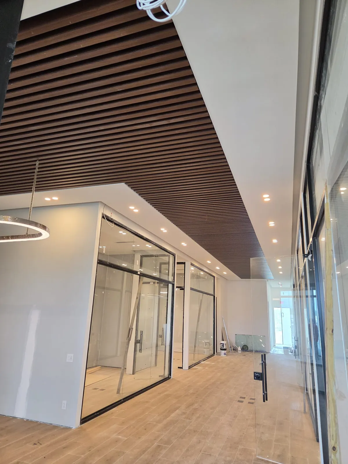 Commercial office fit-out with glass offices and a wood slat ceiling